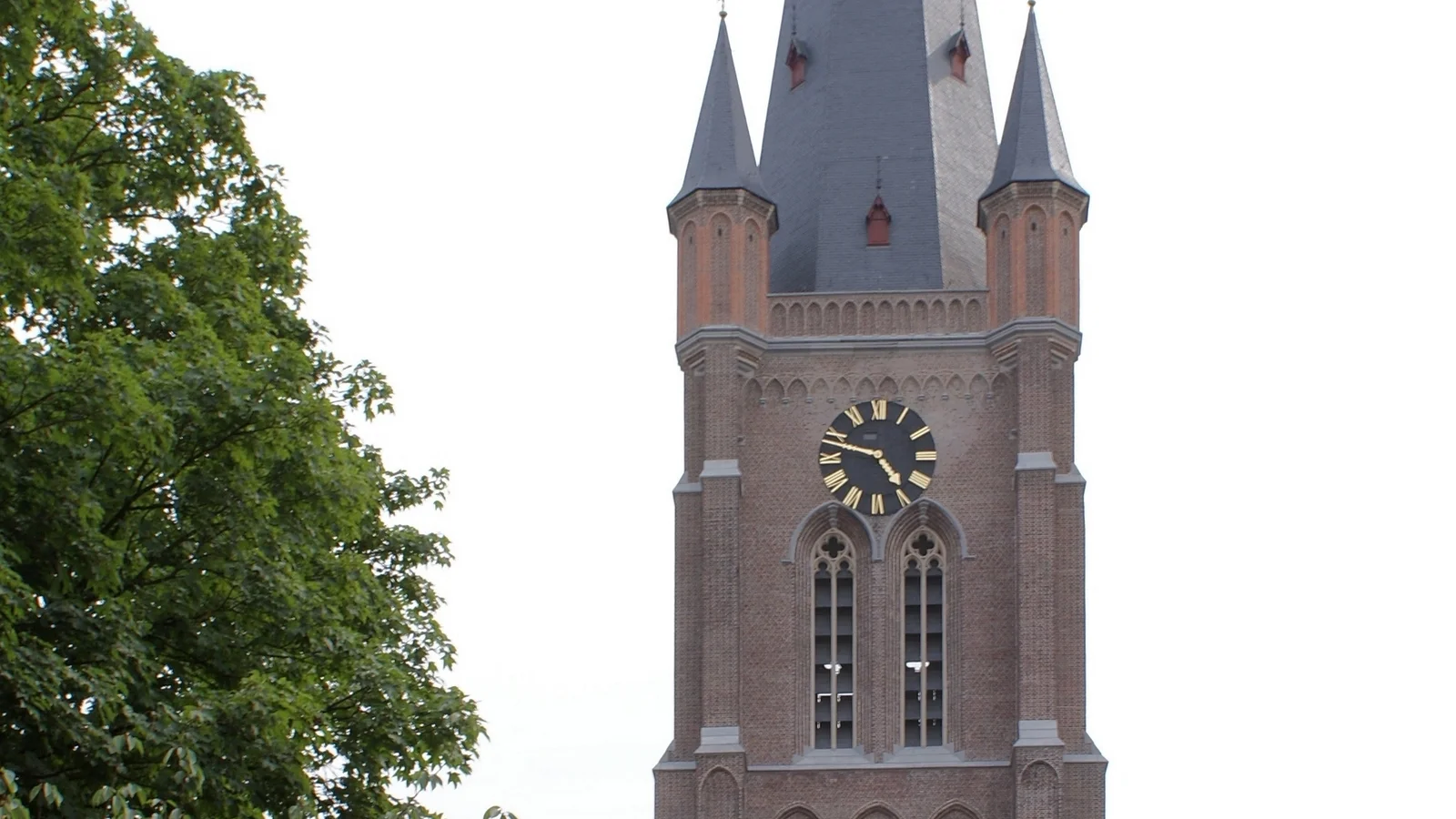 Zijaanzicht van de bijna 100 meter hoge neogotische toren van de Sint-Vincentiuskerk in het centrum van Eeklo.